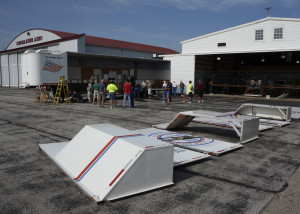 Photo shows side panels removed from Wright B Flyer's custom trailer in preparation for loading the airplane (visible in hangar).